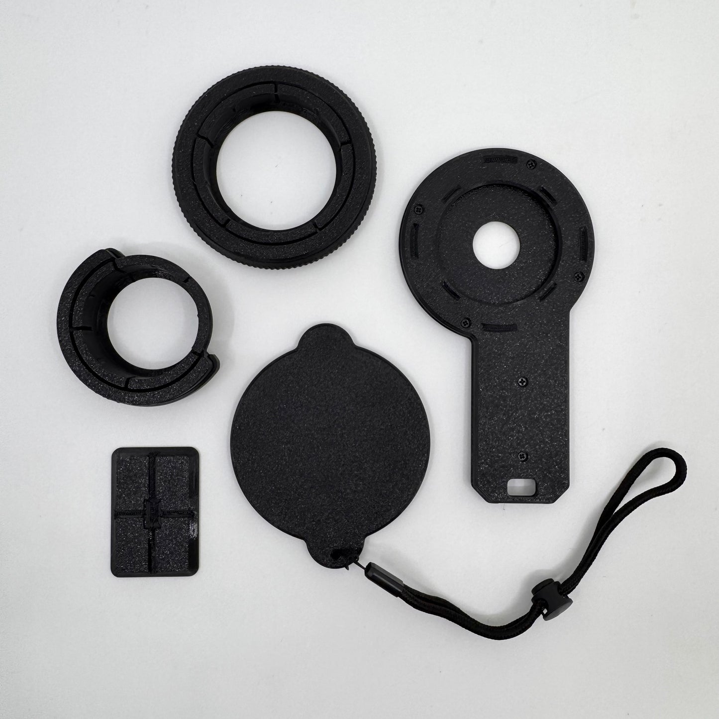 Collection of black camera lens accessories on a white background